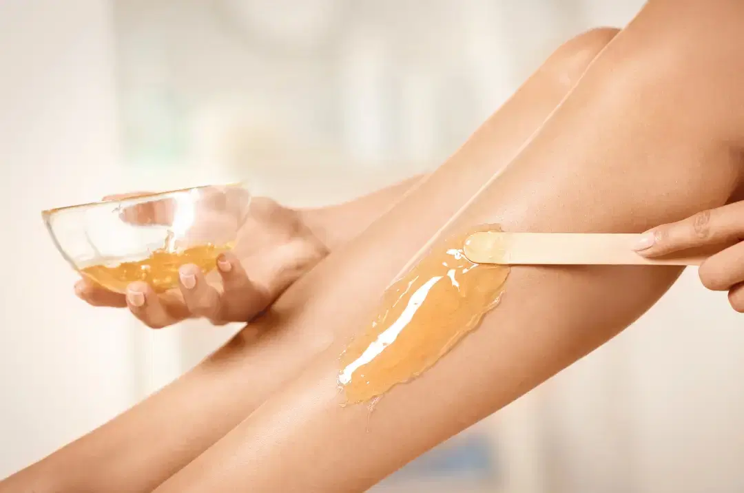 Exfoliating the skin before waxing to prep for a smoother, less painful session