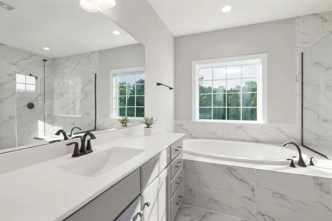 A bright, airy bathroom setup with softening oils and conditioners on the counter