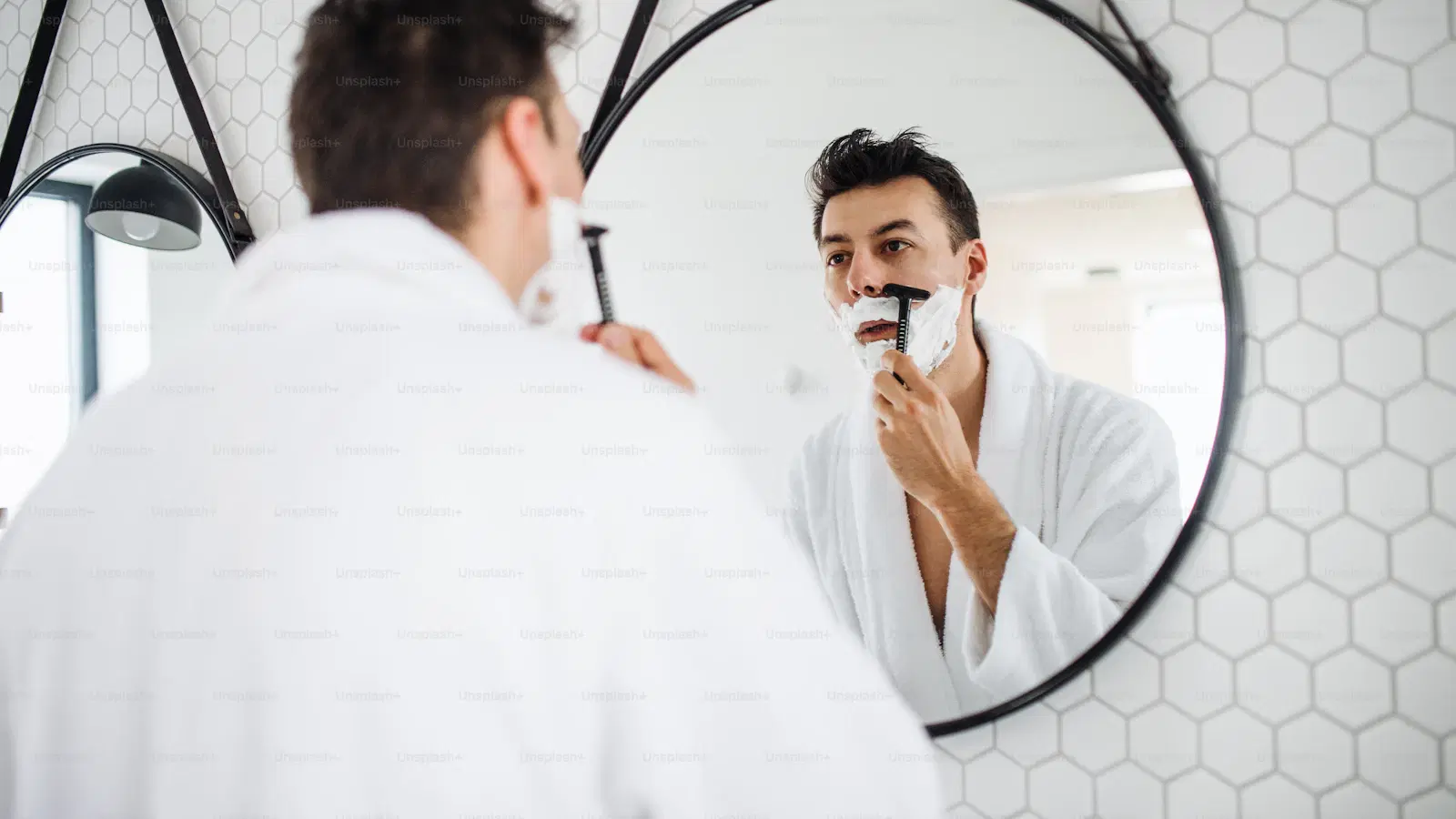 Body trimmer being used on a male chest with a medium-length guard attachment — proper technique for chest hair trimming across variable densities