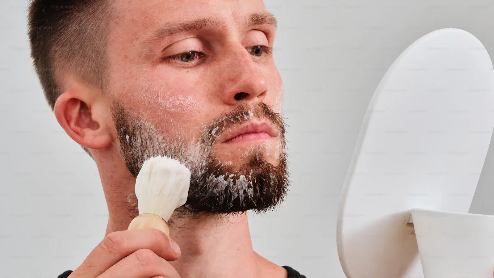 Step-by-step technique diagram for using an electric pubic trimmer safely on men — taut skin, short strokes, with-the-grain direction